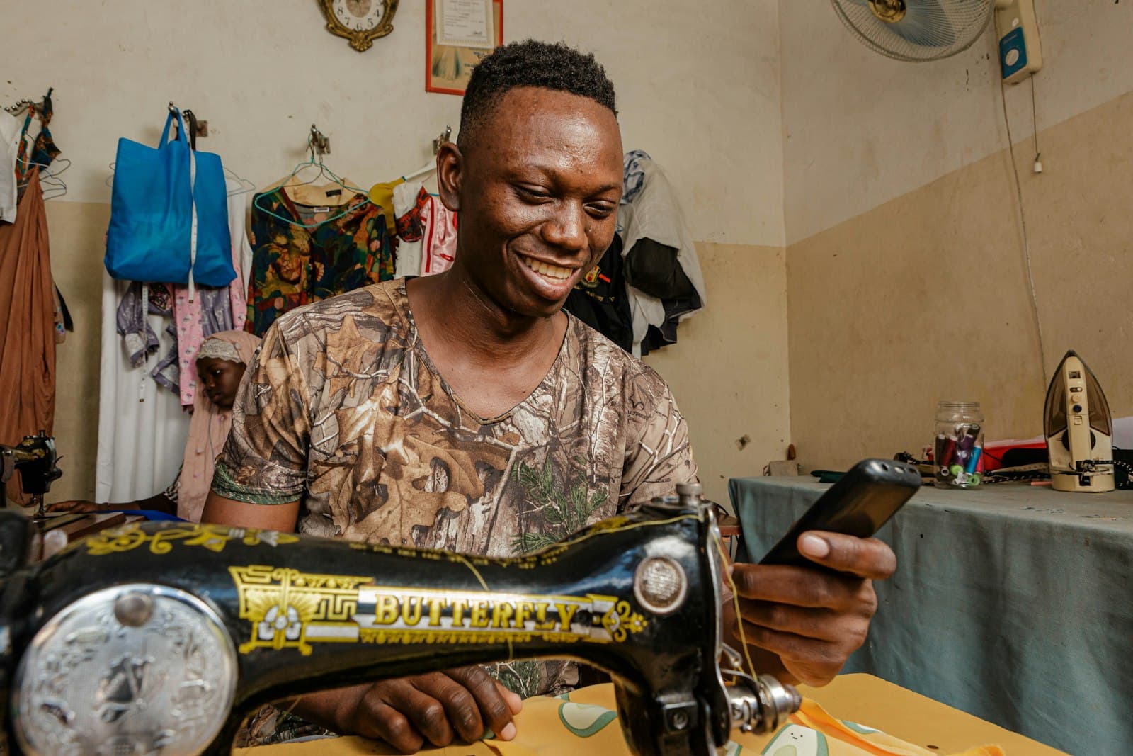 Tailleur souriant à sa machine à coudre